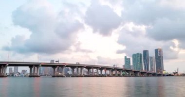 Miami Panorama zaman aşımı. Miami plaj şehrinde gece gökyüzü zamanı. Gökdelenlerin gökyüzü zamanı. Gökyüzünde bulutlar olan gece gökyüzünün zamanı. Günbegün şehrin zaman aşımına uğraması.