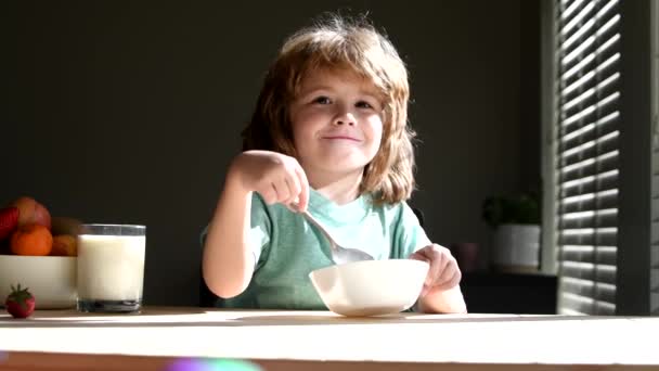 Schattig kind dat thuis ontbijt eet. Kinderen eten pap en melk als ontbijt.. — Stockvideo