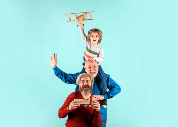 Dziadek i syn bawią się zabawkowym samolotem. Szczęśliwa rodzina. Trzy pokolenia mężczyzn. — Zdjęcie stockowe