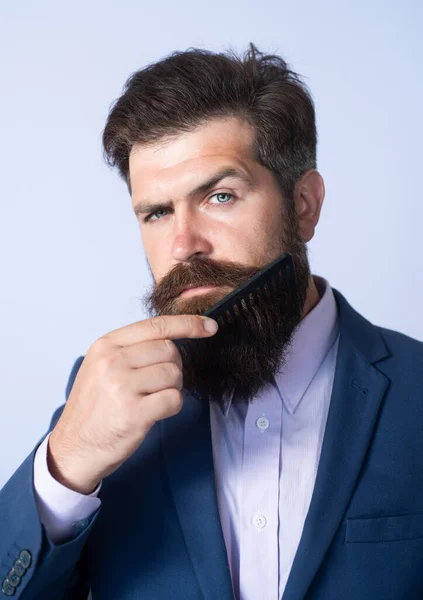 Primer plano de un joven que se peina la larga barba. Cuidado con la barba. Barbudo hombre con barba, barbudo gay. Concepto de barbería. Hombres bigote. — Foto de Stock