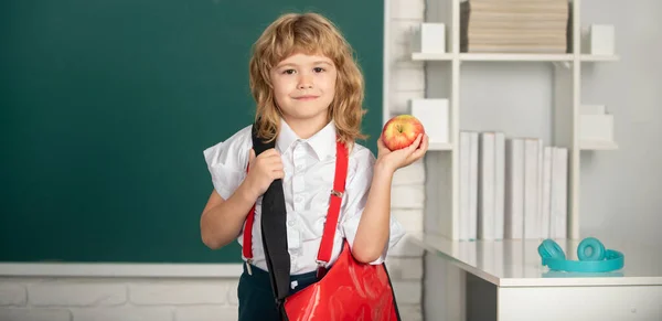 Ragazzo con zaino e mela a scuola. Bambino delle elementari in classe. Genius bambino, giorno della conoscenza. — Foto Stock