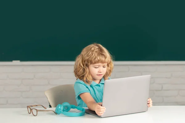 Kid boy het leren van les op school, het maken van huiswerk en met behulp van notebook gadget. — Stockfoto