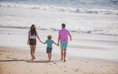 Anne ve baba, yaz mevsiminde Maldivler sahilinde, gün batımında. Arkadaş canlısı aile kavramı.