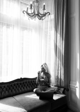 Genç ve çekici bir kadın kahve içiyor, evde dinleniyor. Sıcak, tembel bahar sabahı. Sabahları yatakta uyuduktan sonra güzel bir kız. Yatakta gevşeyen kadın manken uyanın..