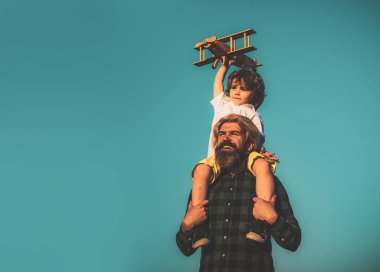 Baba ve oğul dışarıda eğleniyor. Çocuk pilot ve baba uçakla.