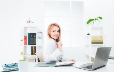 Ofiste çalışan genç ve güzel bir kadın. İş adamları - ofiste defteri olan mutlu iş kadını ya da sekreter.