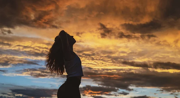 Giovane donna che balla in estate cielo tramonto all'aperto. Stile di libertà delle persone. — Foto Stock