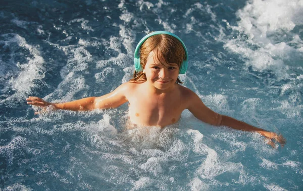 Glücklicher kleiner Junge, der Spaß im Wasser hat und den Sommerurlaub im Pool genießt. Glückliche unbeschwerte Kindheit. Sommerferien für Kinder. — Stockfoto