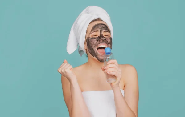 Mujer hermosa excitada con procedimiento facial de barro cosmético, concepto de salud spa. Tratamiento de belleza del cuidado de la piel. Toalla en la cabeza. Barro mineral médico. —  Fotos de Stock