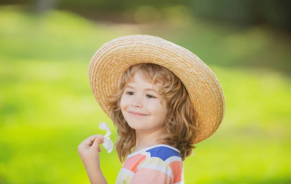 Ritratto bambino caucasico da vicino. Bambini in cappello di paglia con fiore di plumeria. — Foto Stock