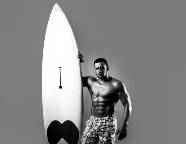 Serfer gespierde man met neon surfplank geïsoleerd op blauw. Mannelijke branding met fit lichaam. Sexy surfer met een surfplank. Zomer sport. — Stockfoto