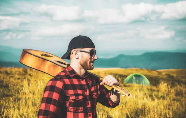 Der Mensch genießt die Natur. Schöner Reisender mit Gitarre im Herbstberg. — Stockfoto