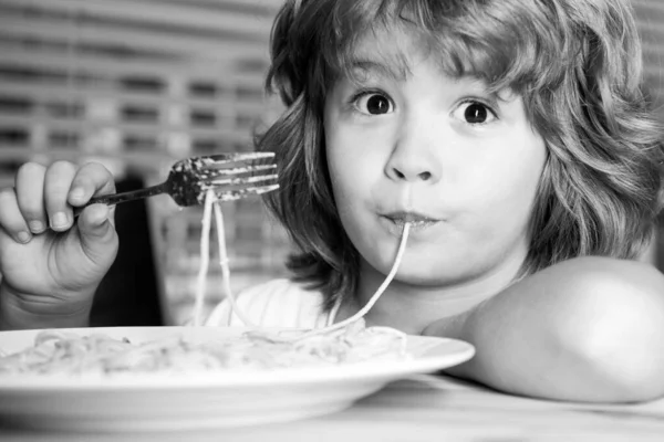 Criança engraçada comendo macarrão, espaguete, cara de perto. Retrato de cabeça de crianças. — Fotografia de Stock