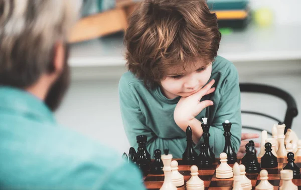 Otec učí syna hrát šachy. Pojetí vzdělávání a výuky. Učitel a dítě. Hezký otec a syn hrají šachy, zatímco tráví čas spolu. — Stock fotografie