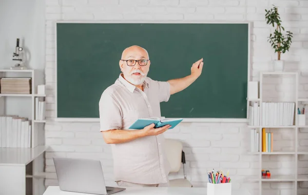 Retrato de la línea de enseñanza de profesores senior de estudiantes de secundaria con cuaderno en el aula en pizarra. Día del maestro. —  Fotos de Stock