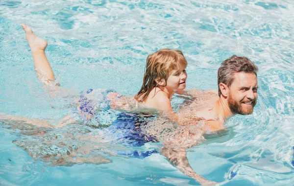 Father and son swimming in pool, summer family. Dad and son leisure. Swimming lessons.