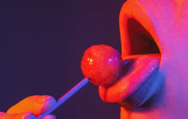 Parmak izi için şekerli seksi kırmızı dudaklar. Sanat tasarımında ağzında kırmızı, tatlı bir lolipop. Parlak kadın dudakları lolipop yalıyor. Şehvetli seksi ağız ve şeker kavramı. Güzel kadın dudakları..