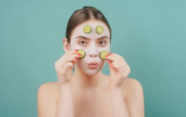 Güzellik tedavileri. Yüz maskesi. Cilt bakımı. Yüzünde salatalık dilimleri olan bir kadın..