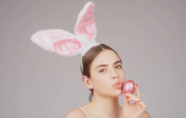 Кролик дівчина з пасхальним яйцем. Кролик дівчина з кольоровим яйцем. Жінка в кролячих вухах. Полювання на яйця . — стокове фото
