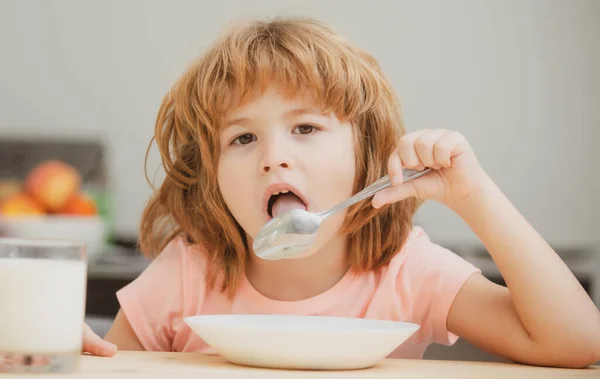 Niño pequeño caucásico comiendo sopa saludable en la cocina. Nutrición infantil. — Foto de Stock