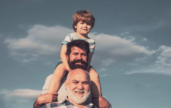 Glücklicher Vatertag. Großvater spielt. Junge mit Vater und Großvater genießen gemeinsam im Park vor blauem Himmel. — Stockfoto