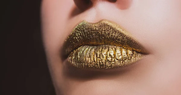 Gouden lippen. vrouw sexy lip make-up geïsoleerd op zwart achtergrond. — Stockfoto