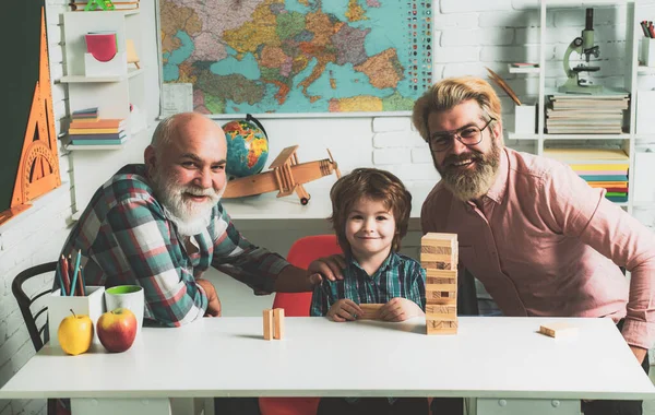 Jenga gioco a casa. Ridendo nonno con figlio e nipote rilassante trascorrere il fine settimana a casa. Buon bambino padre e nonno tempo libero divertimento . — Foto Stock