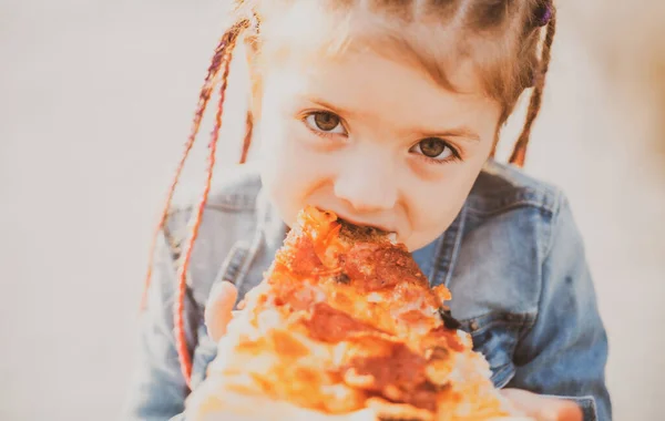 Çocuk pizza yiyor. Çocuklar için fast food. Abur cubur bağımlılığı. İtalyan mutfağı. Çocuk maması. Çocukluk obezitesi. Çocuk için lezzetli yemekler.. — Stok fotoğraf