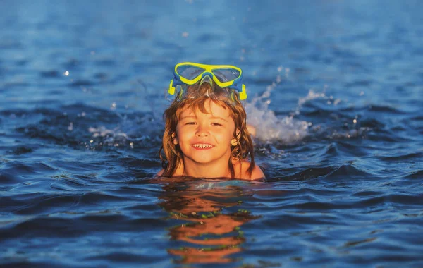 Letnie dziecko. Zabawne dziecko na plaży. Chłopak pływa w morzu w letnie wakacje. Szczęśliwe dzieciaki pływające w wodzie. Mały chłopiec pływający w oceanie lub morzu. — Zdjęcie stockowe