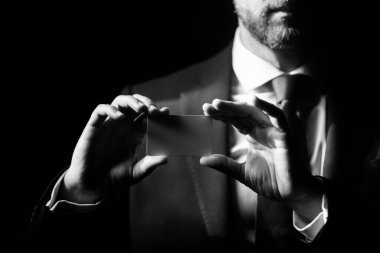 Kredi kartı sahibi bir iş adamı. Elinde boş bir kredi kartı modeli var. Kredi kartı el ele tutuşmanın şablonunu oluşturur. Plastik banka kartı. Ticari marka.