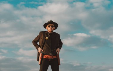 Şerif ya da şerif. Kovboyla vahşi batı. Dışarıda silahlı, ciddi bir adam var..