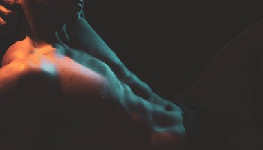 Kaslı vücutlu, sportif bir adam. Mükemmel karın kasları olan atletik bir adama yakın çekim. Genç adamın kaslı seksi gövdesi.