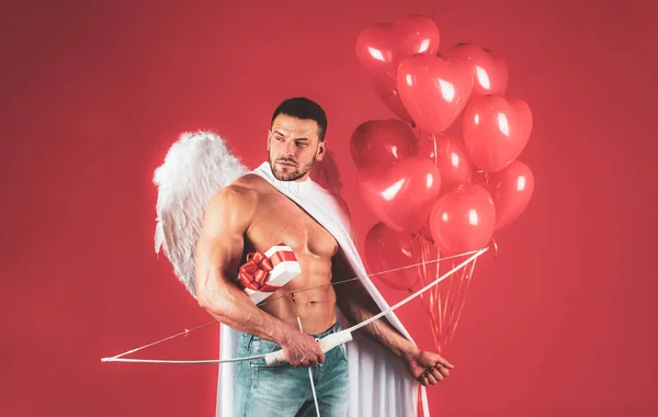 Un hombre sexy en San Valentín. Símbolo del amor. Un tipo disfrazado de ángel. Cupido con lazo. 14 de febrero. Hombre ángel guapo con alas de ángel. Gran regalo para la novia. Angelical desnudo joven chico. — Foto de Stock