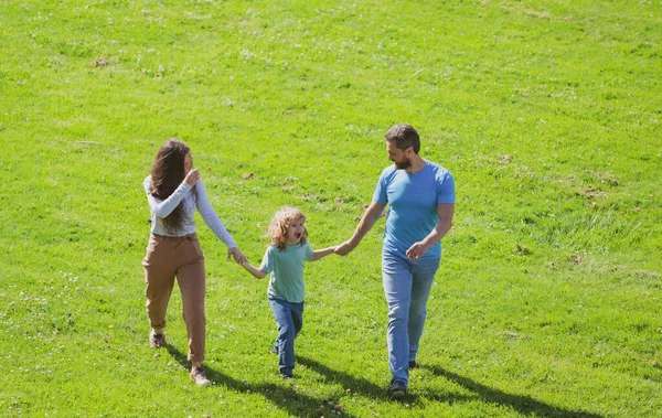 Ευτυχισμένοι νέοι γονείς περπατούν με παιδί έξω στο πάρκο. Ευτυχία και αρμονία στην οικογενειακή ζωή. — Φωτογραφία Αρχείου