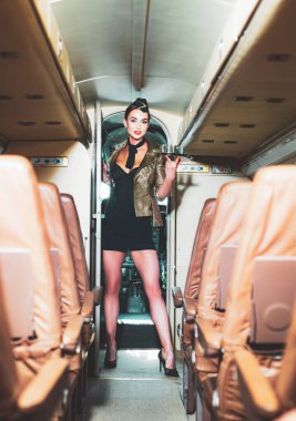 Hostes üniforması. Güzel hostes. Uçakta gülümseyen güzel bir hostes. Havayolu. Kadın ve ticari uçak. Hostesle uçak kabini..