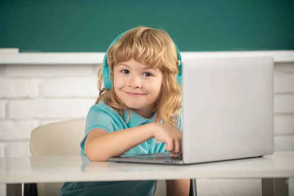 Leuk grappig kind met behulp van laptop computer, kid boy studeren door middel van online e-learning. Kleine grappige systeembeheerder. — Stockfoto