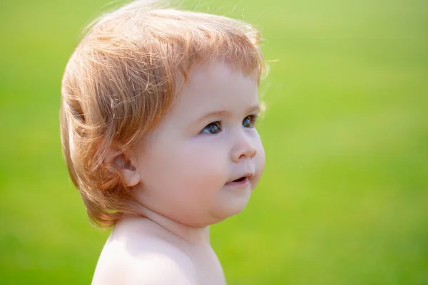 Söt liten bebis på ängsfältet. Leksaksbarn promenader utomhus, familjesemestrar, sommarsäsong natur. Baby ansikte på nära håll. Lustigt litet barnporträtt. Blond unge, känslomässigt ansikte. — Stockfoto