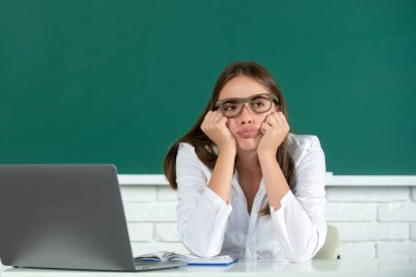 Sınav hazırlayan ve okulda ders öğrenen öğrenci. Üzgün, ciddi ve ilgili bir öğrenci kız..