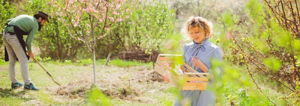 Aliments biologiques cultivés au pays. Jeune couple jardinage dans le jardin. La vie rurale. Portrait de deux fermes travaillant ensemble dans le jardin. Conception de printemps pour bannière ou en-tête de site Web, espace de copie. — Photo