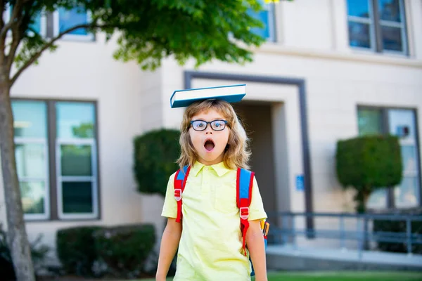 Joyeux enfant souriant dans des lunettes va à l'école pour la première fois. Les élèves vont étudier. Enfant garçon avec sac aller à l'école primaire. Enfant de l'école primaire. Retour à l'école. — Photo