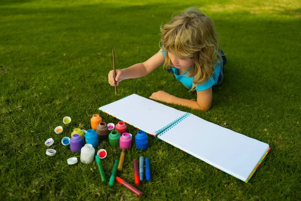 Menino desfrutando de arte e desenho de artesanato no quintal ou no parque da primavera. Crianças desenho desenhar com lápis ao ar livre. — Fotografia de Stock