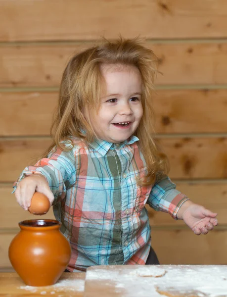 Bambino in cucina che cucina, giocando con le uova. Bambino per rompere l'uovo. — Foto Stock