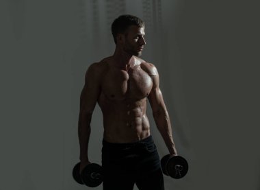 Sportif gövde, dambılı adam. Kaslı ve güçlü adam egzersiz yapıyor. Sporcu ağırlıklarla egzersiz yapıyor. Fitness ve Crossfit.