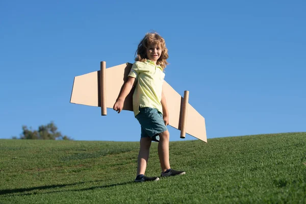 緑の芝生の背景に公園でおもちゃの翼で遊ぶ子供. — ストック写真