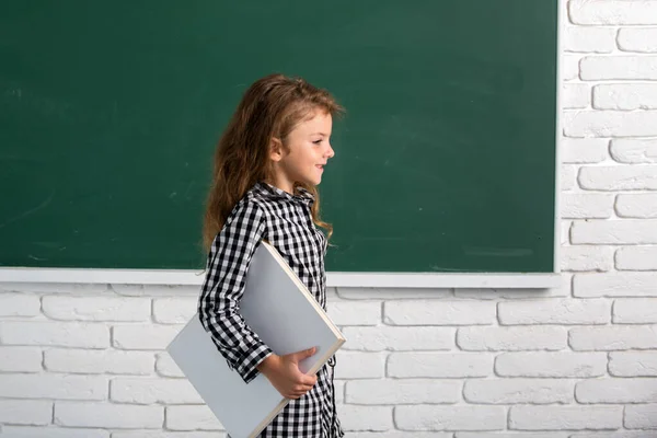 Söta barn i skolan. Grabben lär sig i klassen på bakgrund av svarta tavlan. Genialiskt barn, kunskapsdag. — Stockfoto