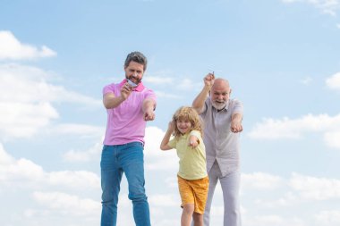 Nesiller boyu birlikte, gülümseyen oğul, baba ve büyükbabanın oyuncak bir uçakla portresi. Çocuk uçakla oynuyor ve geleceği hayal ediyor..