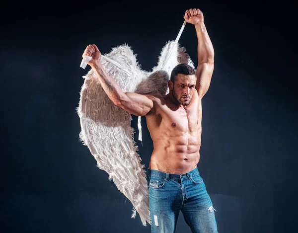 Svalnatý silný krásný svlečený mužský anděl. Hezký mladý atletický muž s holým trupem vypadá jako anděl s bílými křídly. Valentýn. — Stock fotografie