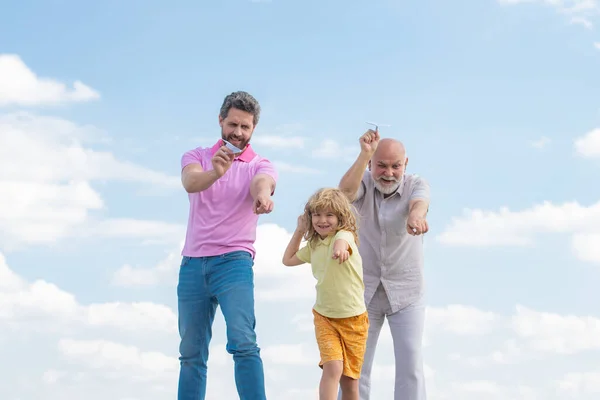 Generaciones de hombres juntos, retrato de un hijo sonriente, padre y abuelo con un avión de juguete. Niño jugando con avión y soñando futuro. — Foto de Stock