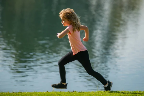 Kinder joggen im Park im Freien. Kleiner Junge läuft in der Natur. Aktive gesunde Kinderläufer joggen im Freien. Joggen hilft dem Körper, stark zu sein. — Stockfoto