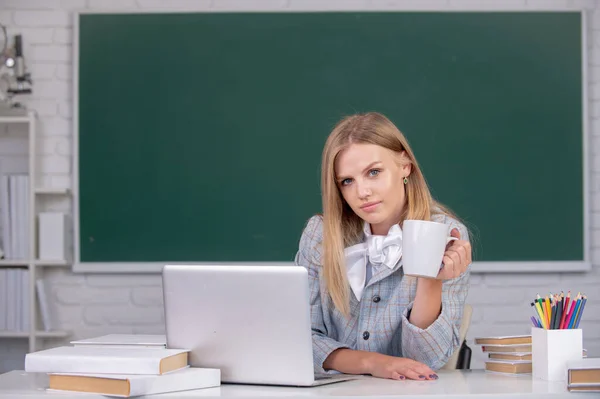 Portret van een leuke aantrekkelijke jonge vrouw student die koffie of thee drinkt op de universiteit of middelbare school. — Stockfoto